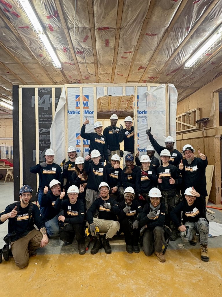 Photo d'un groupe de participants au CMC dans un atelier de menuiserie et d'isolation