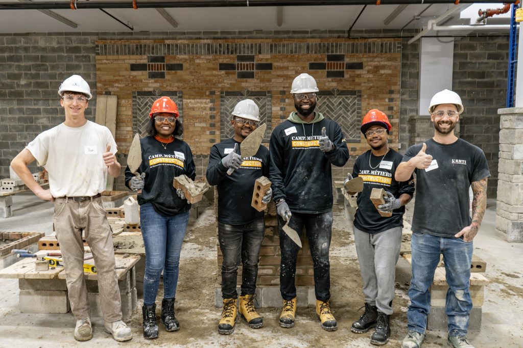 Photo d'un groupe de participants au CMC dans un atelier de maçonnerie